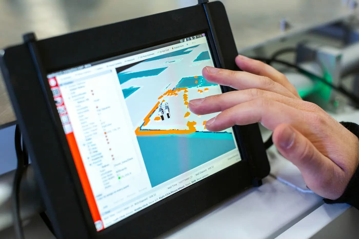 Hand an einem industriellen Bedienpanel mit einer technischen Darstellung.